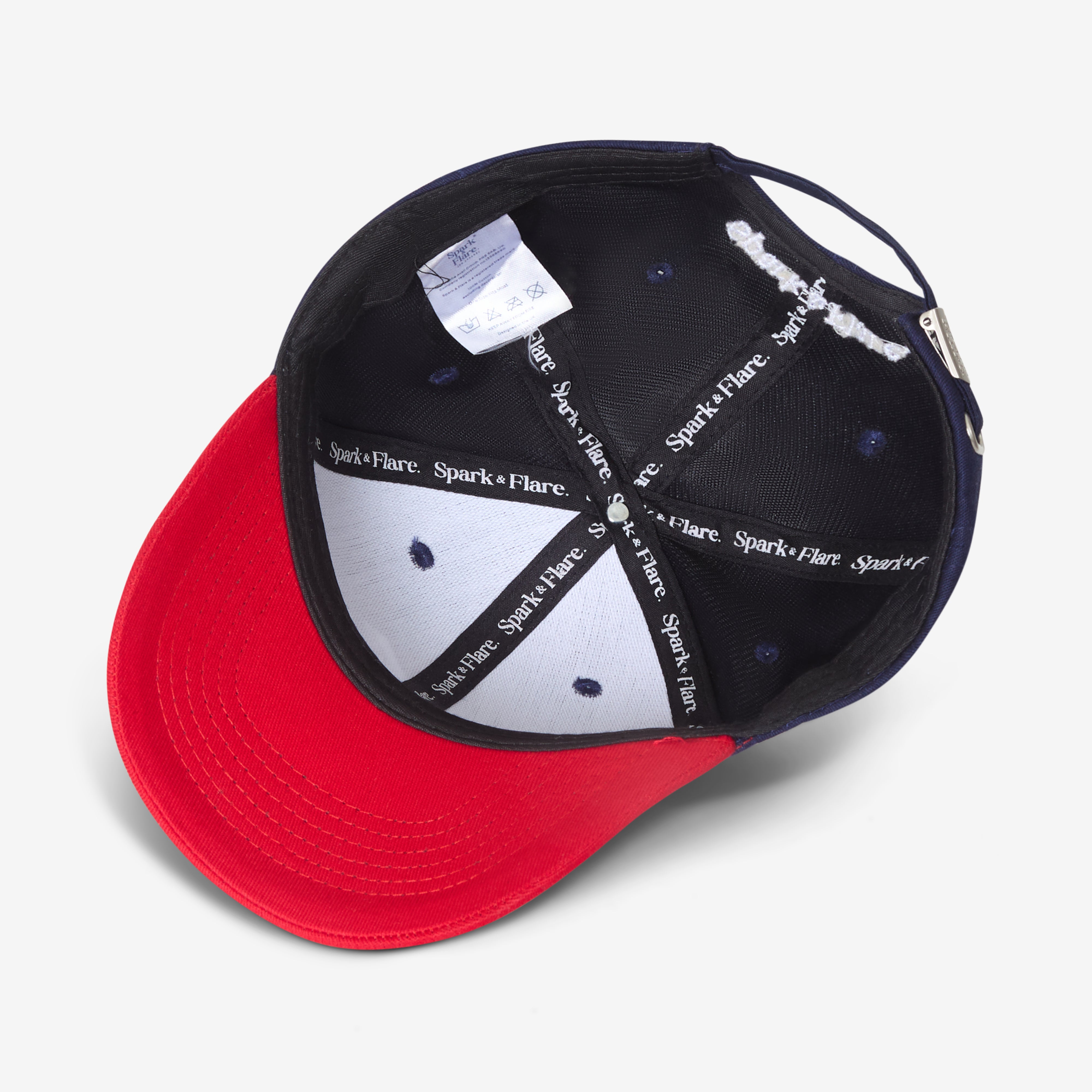 Inside of a navy and red cap with Spark & Flare branded lining