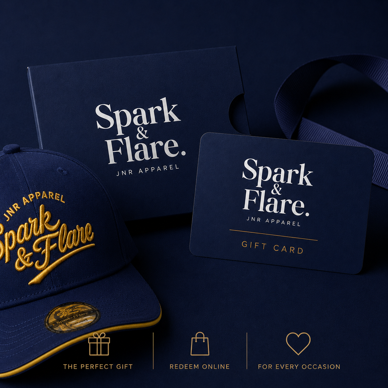 Spark & Flare JNR Apparel gift set featuring a navy blue branded gift box, a matching gift card, and a navy blue baseball cap with gold gold embroidery.
