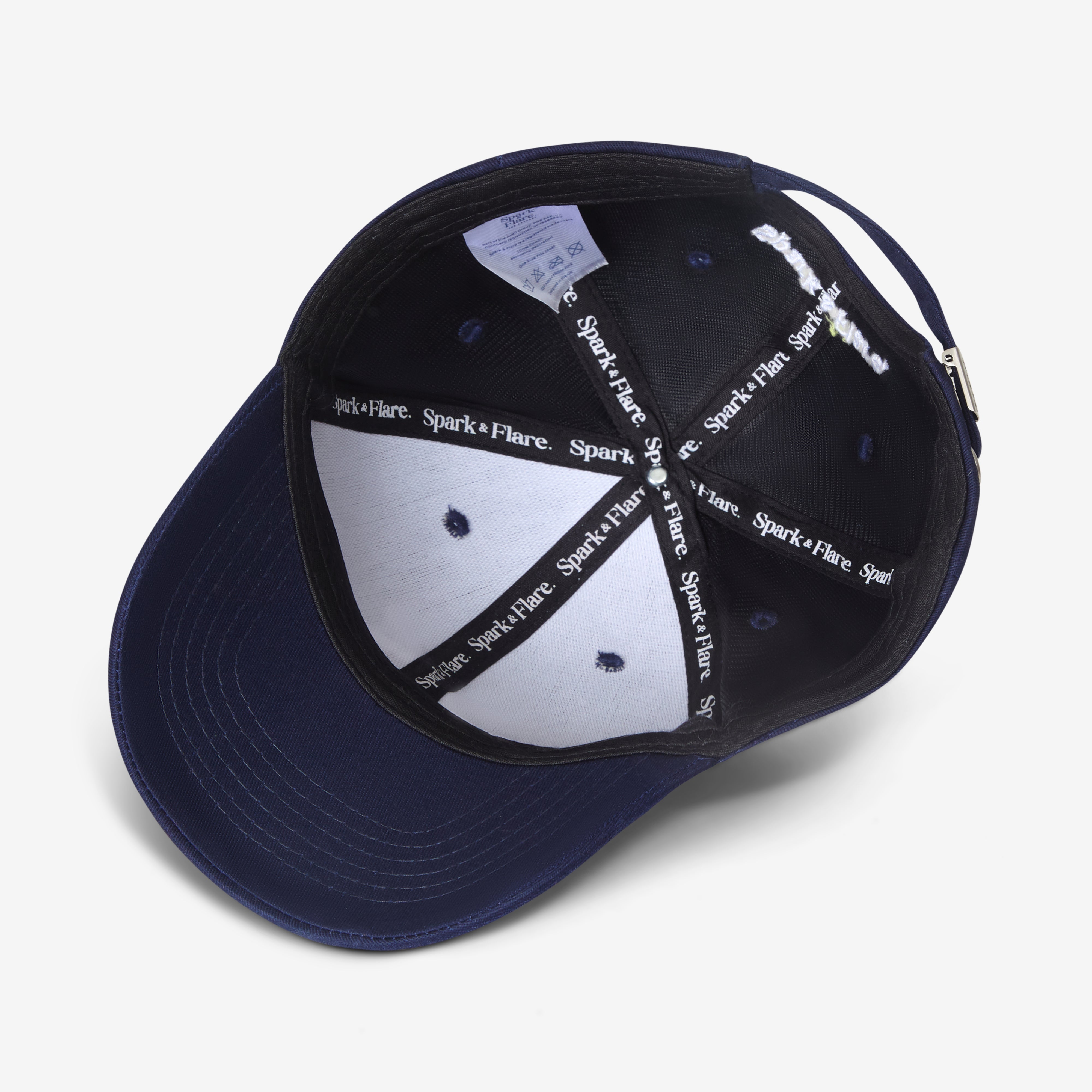 Inside of a Navy blue cap with white and black branded Spark & Flare lining
