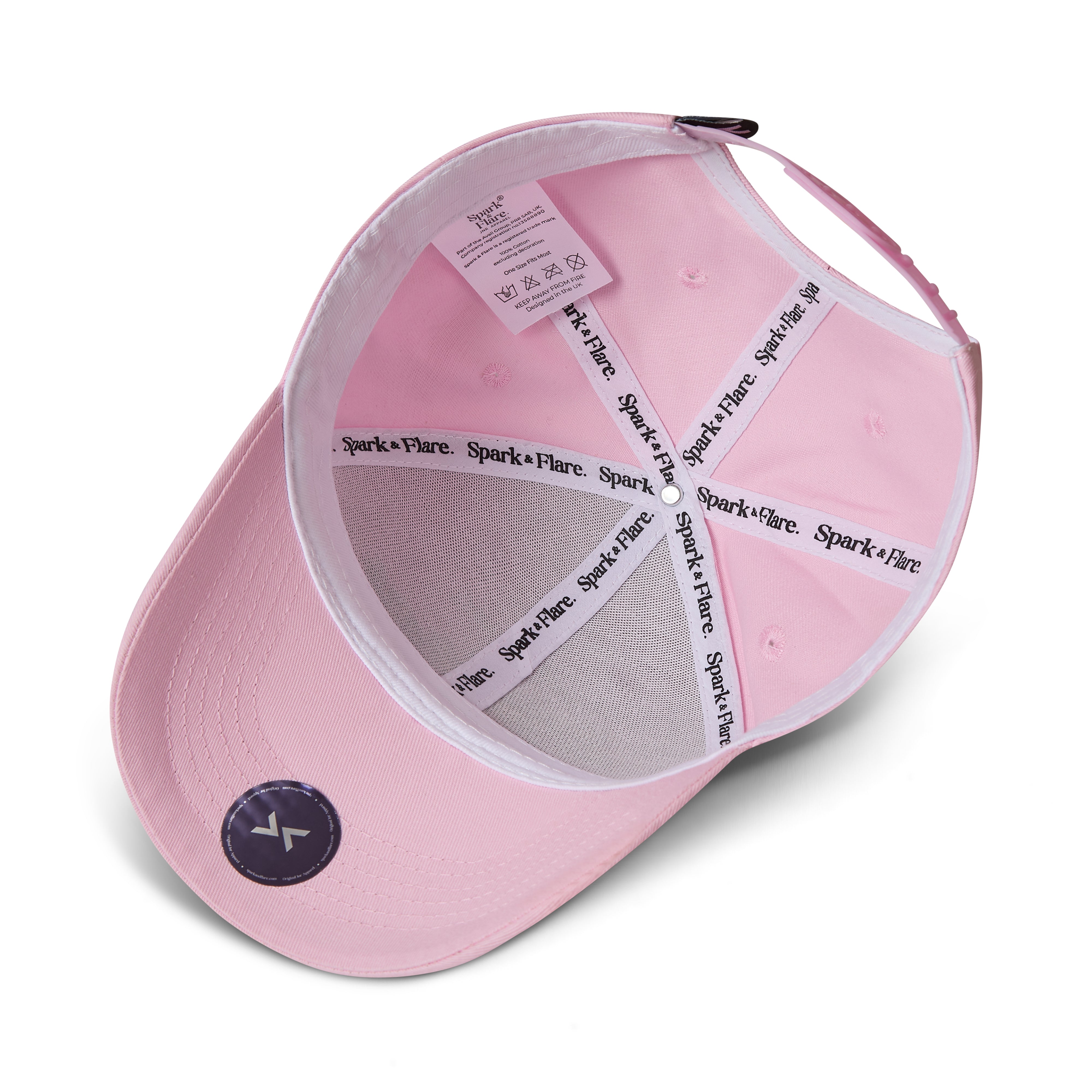 A light pink baseball cap shown from an overhead angle, revealing the interior. The cap features a white mesh back panel, white elastic straps with 'Spark + Flare' printed in black, and a small circular black logo patch on the brim.
