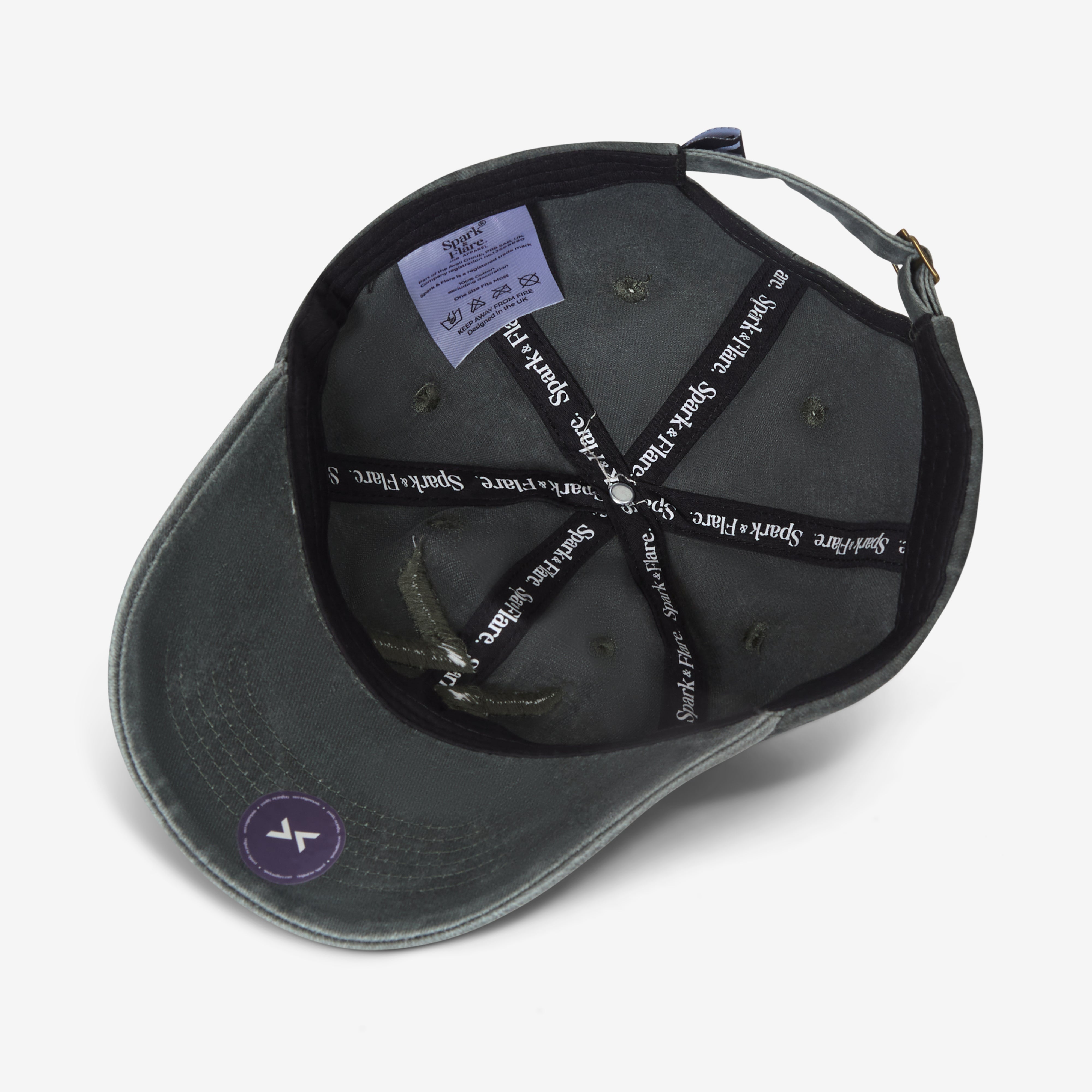 Inside of a washed green Spark & Flare baseball cap with branded lining